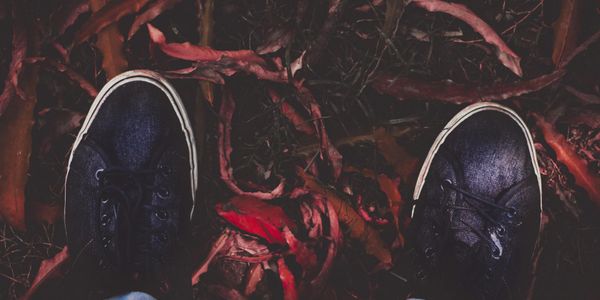 Top-down view of training shoes on a dark, textured floor.
